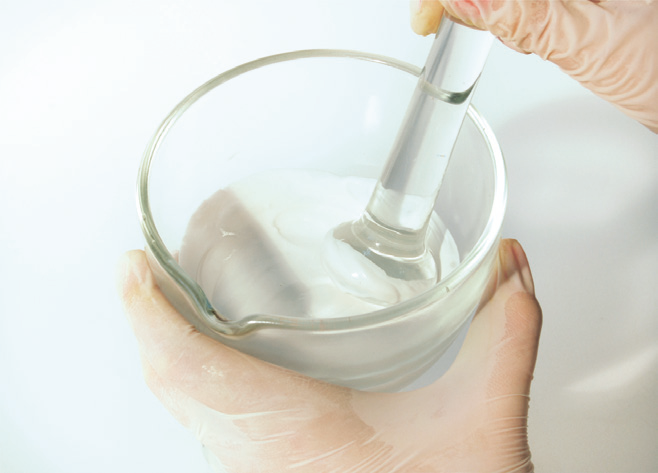 a person holding a glass beaker with a pipette