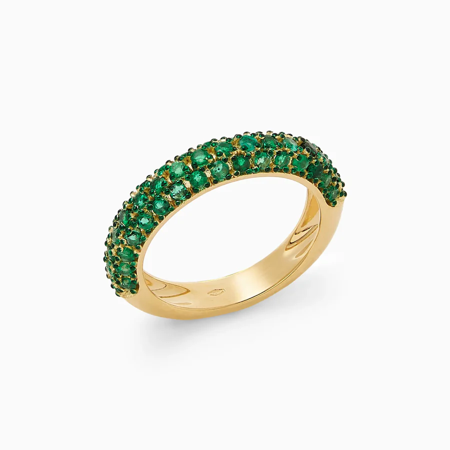 a gold ring with green gemstones
