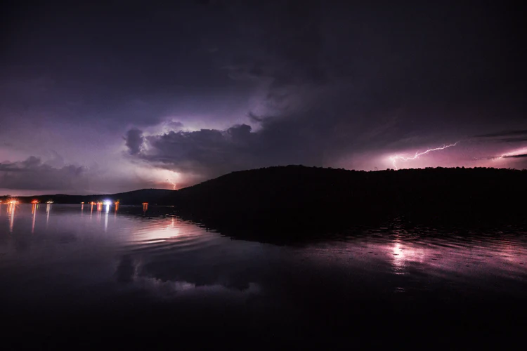 a body of water with lightning in the sky