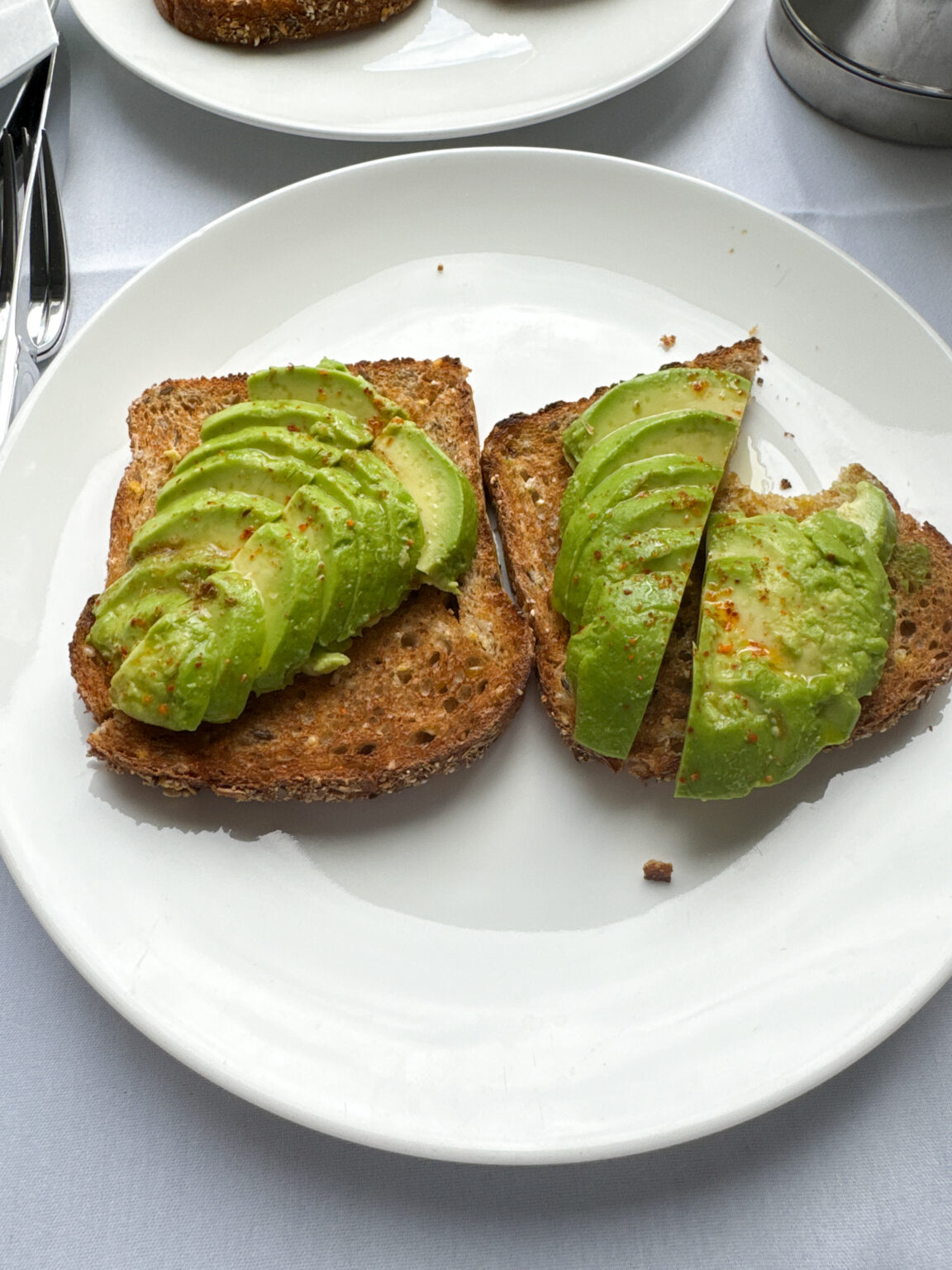 a plate of toast with avocado on it