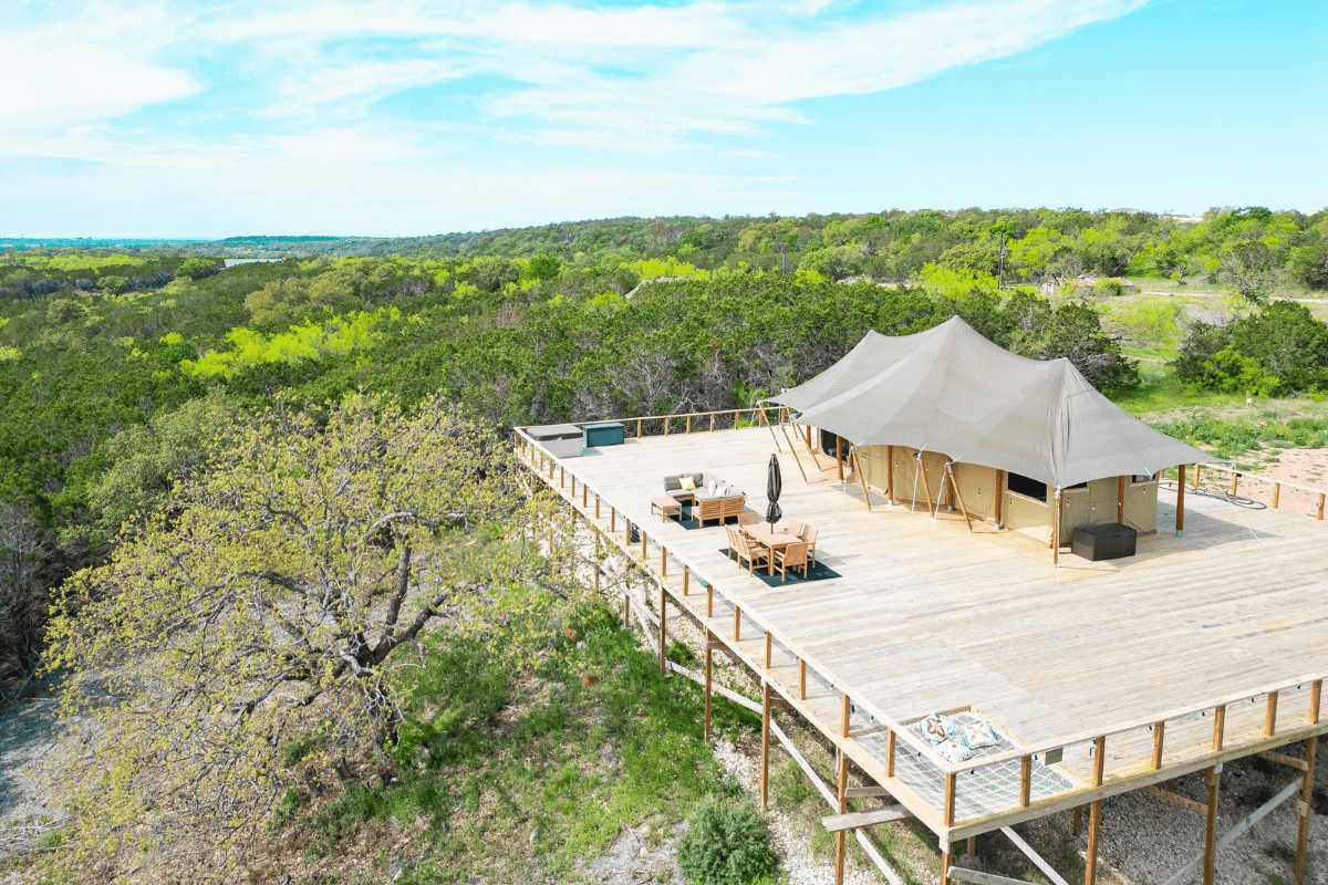 a large tent on a deck surrounded by trees