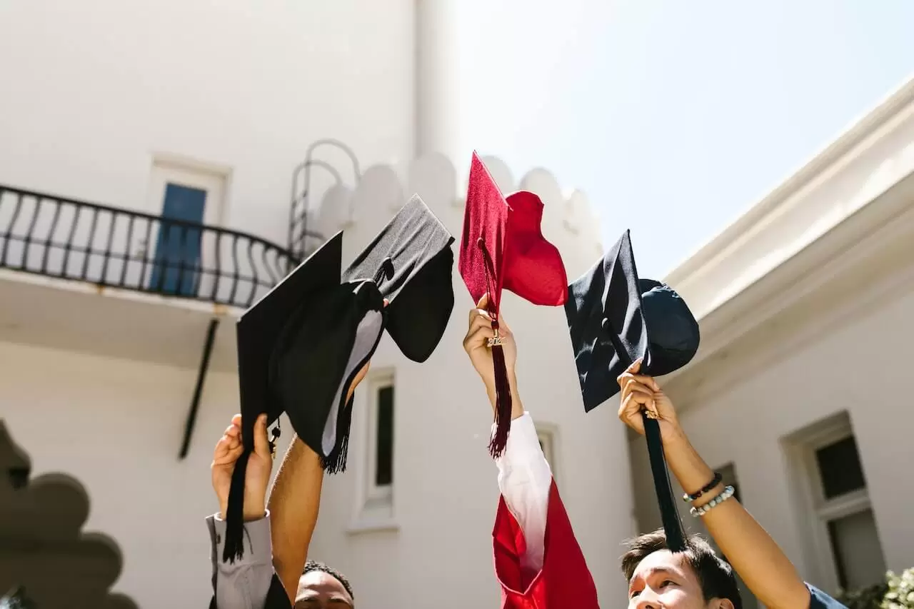a group of people holding graduation caps