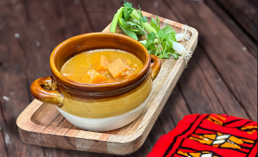 a bowl of soup on a wooden tray