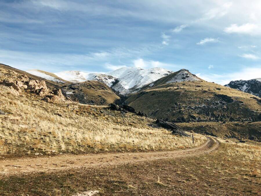a dirt road through a snowy mountain