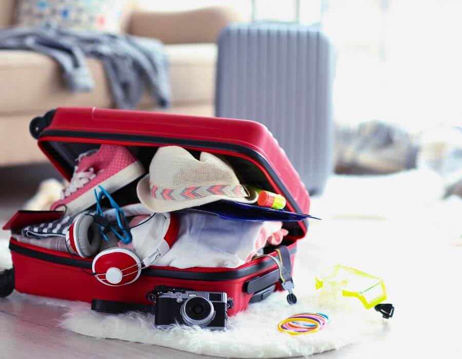 a red suitcase with clothes and accessories