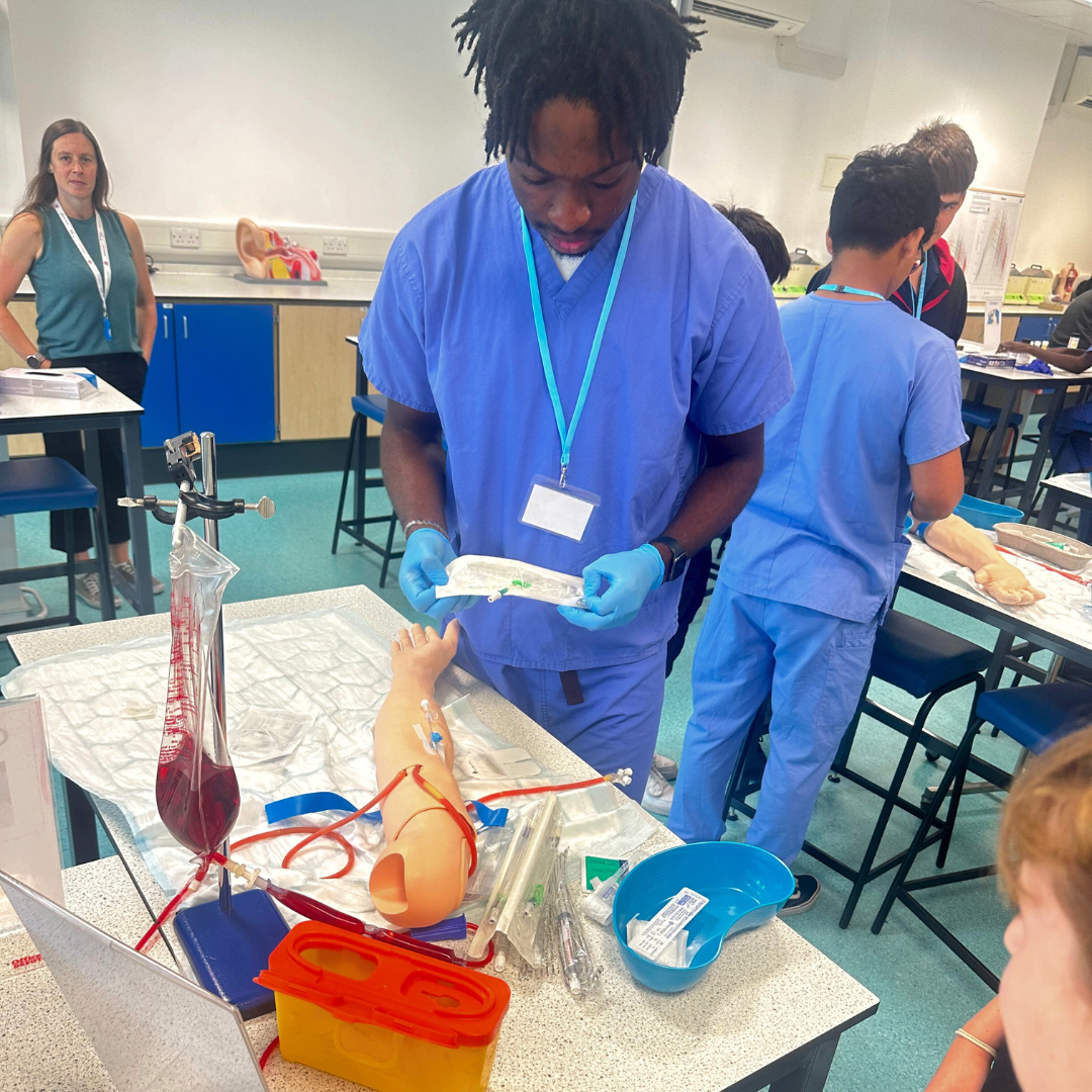 a man in blue scrubs and gloves holding a plastic object