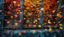 a window with falling leaves