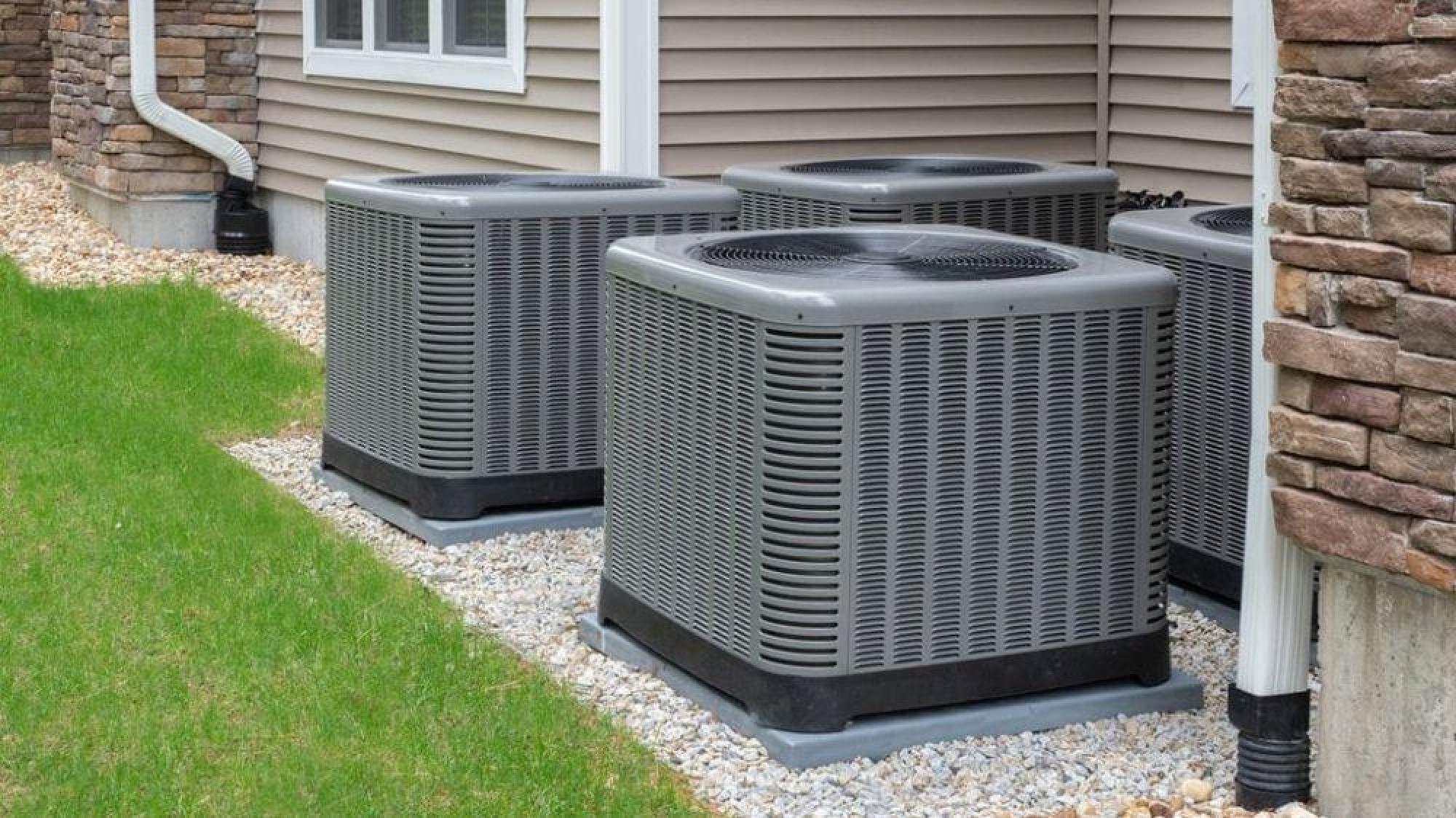 a group of air conditioning units outside of a house