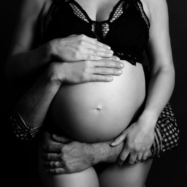 a man holding a pregnant woman's belly