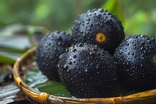 a group of black fruit in a basket