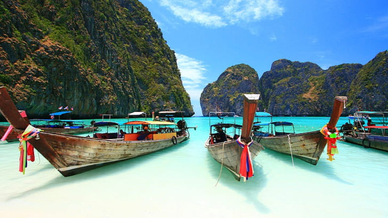 boats in the water with mountains in the background with Phi Phi Islands in the background