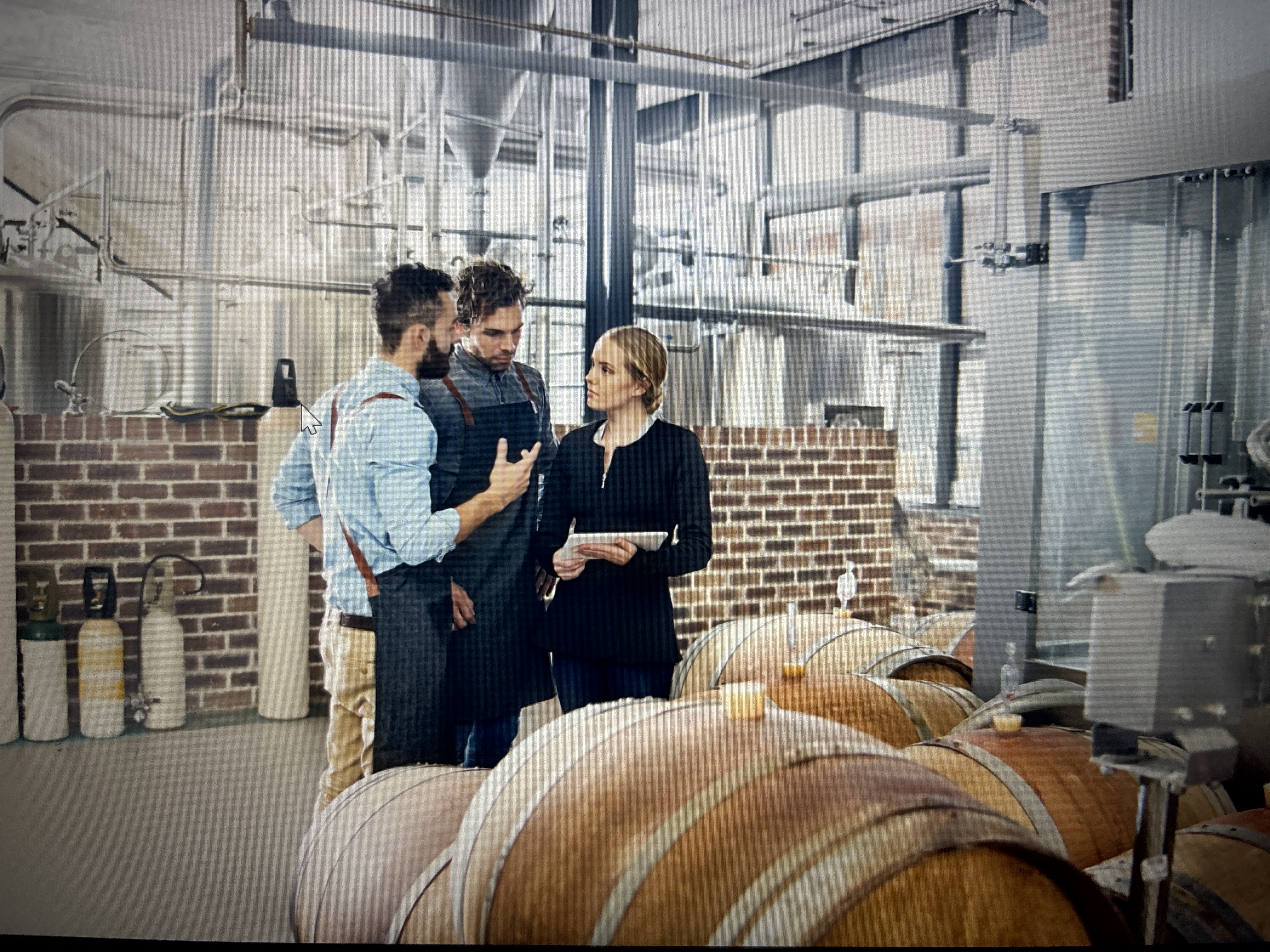 a group of people standing in a room with barrels