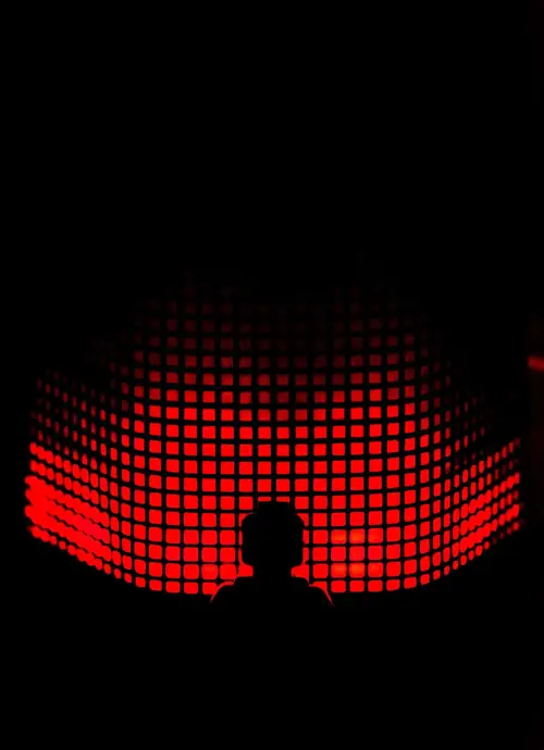 a person standing in front of a red screen