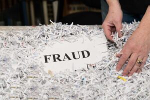 a person's hands touching a sign surrounded by shredded paper