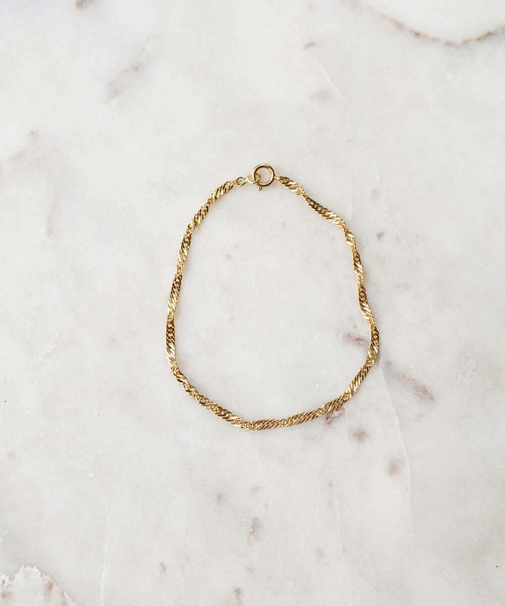 a gold chain on a marble surface