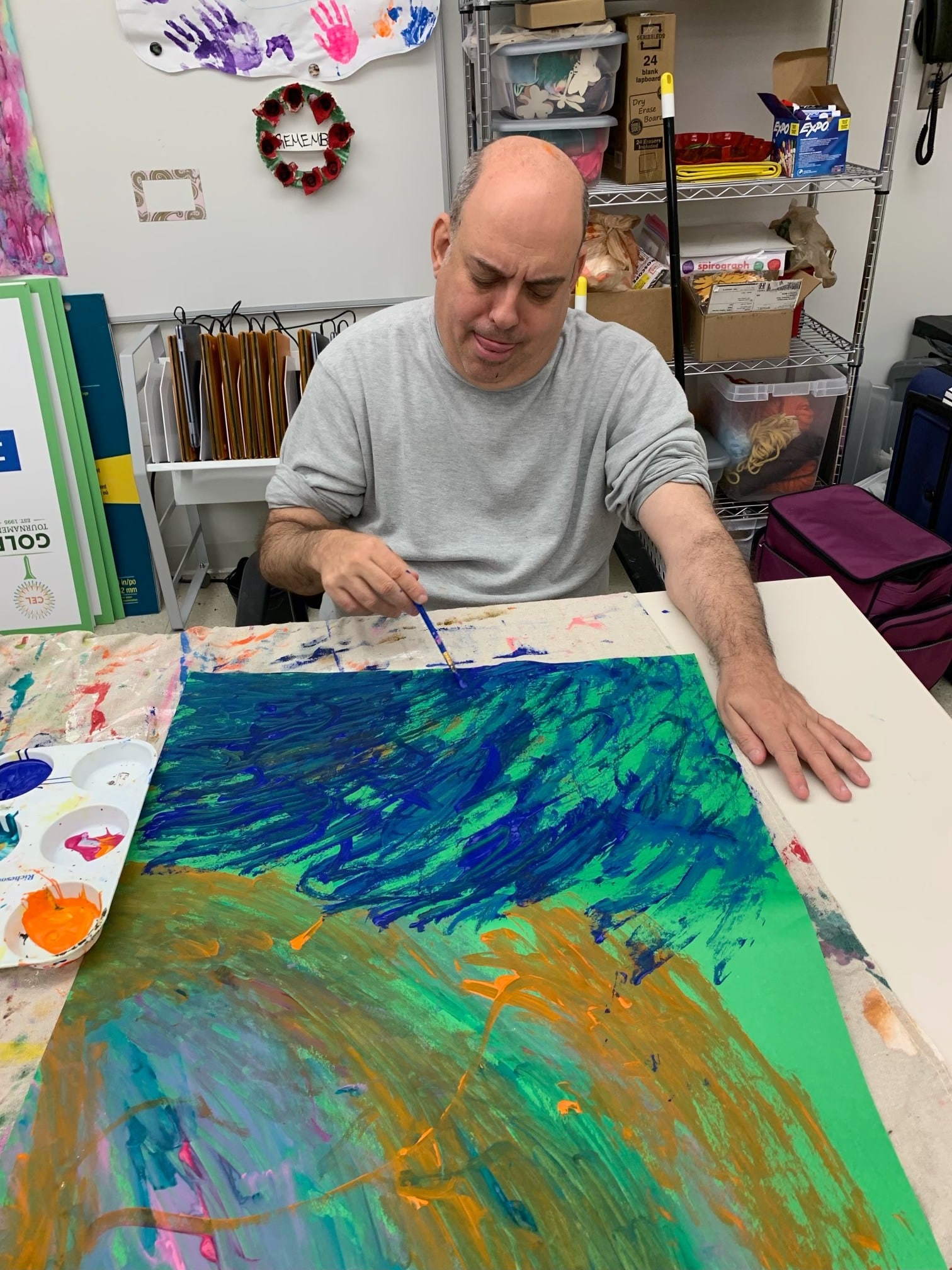 a man sitting at a table painting