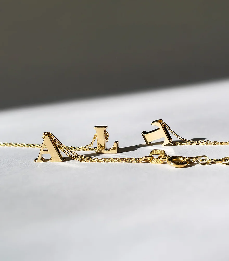 a gold necklace with letters on it