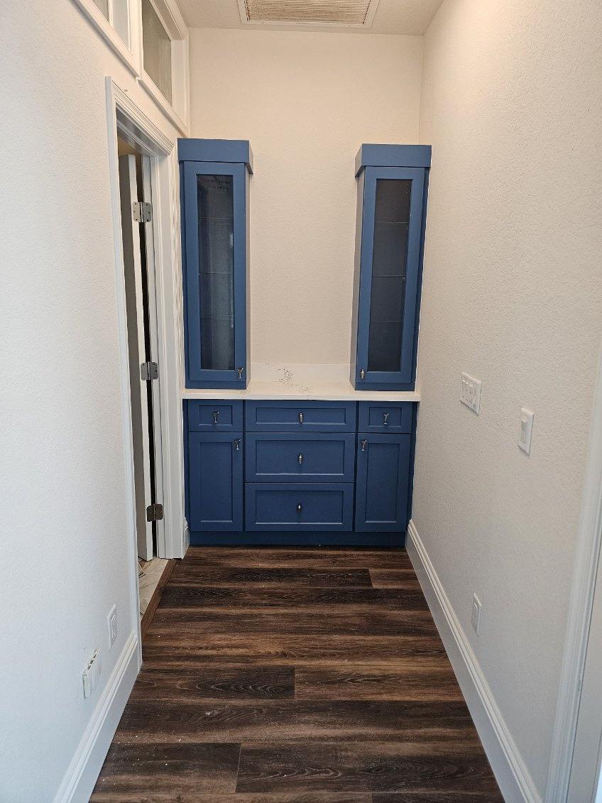 a room with blue cabinets and wood floors