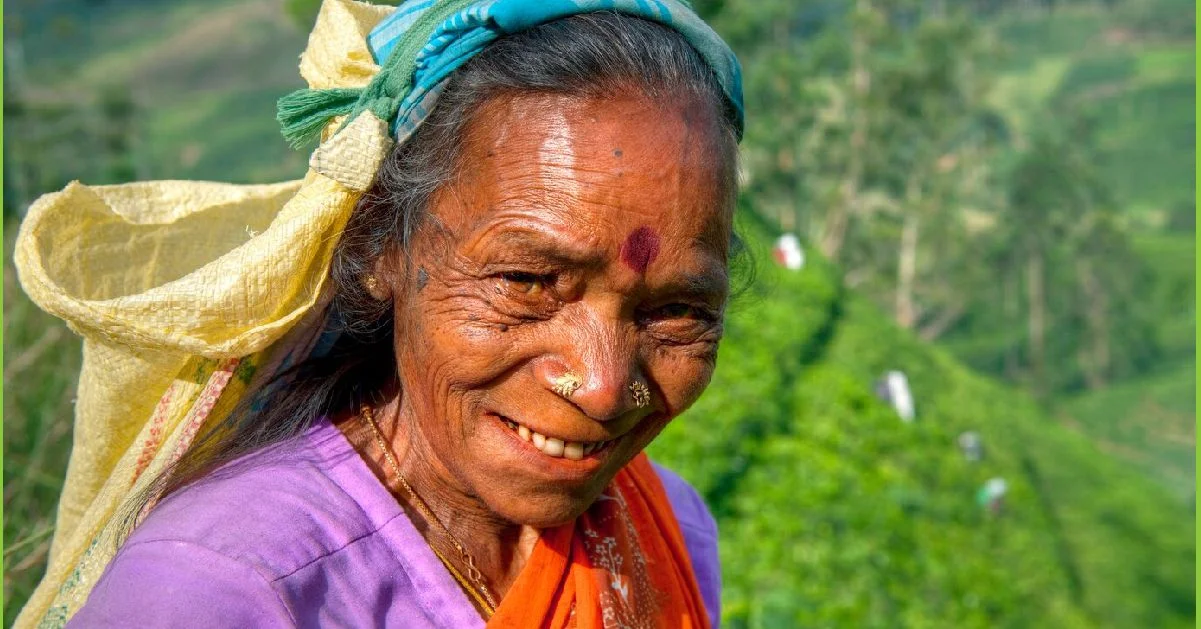 a woman smiling with a colorful head scarf