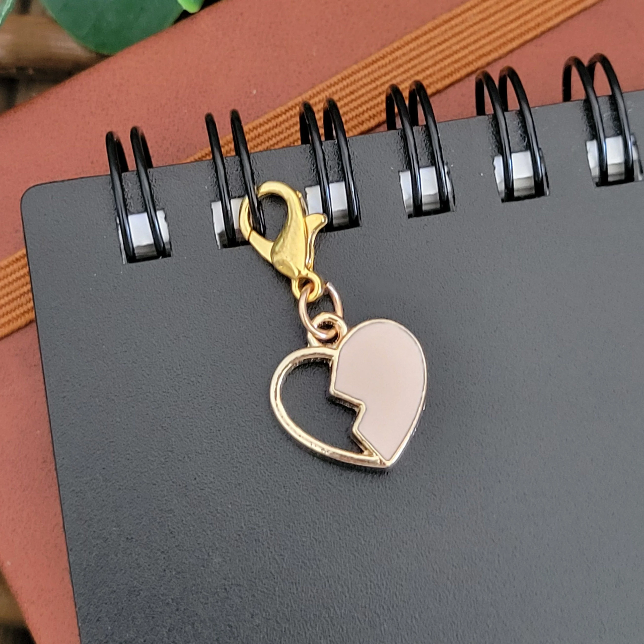 a heart shaped keychain on a spiral notebook