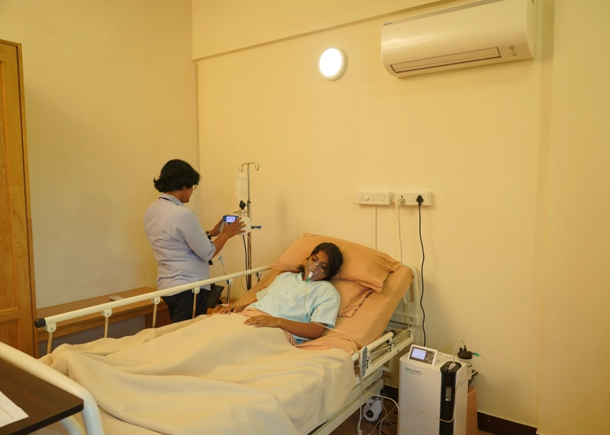 a woman lying in a hospital bed with a mask