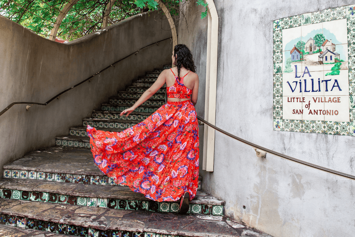 a woman in a red dress walking up stairs