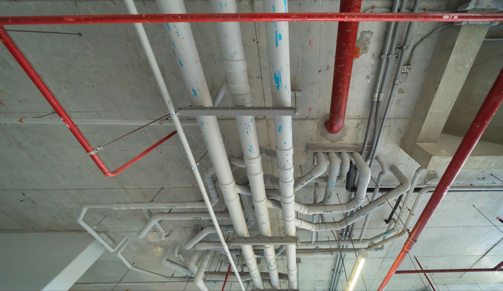 a white pipes on a concrete ceiling
