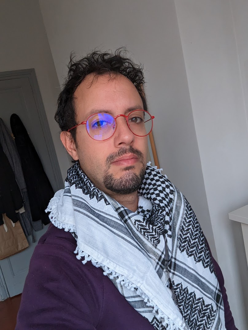 a man wearing glasses and a scarf