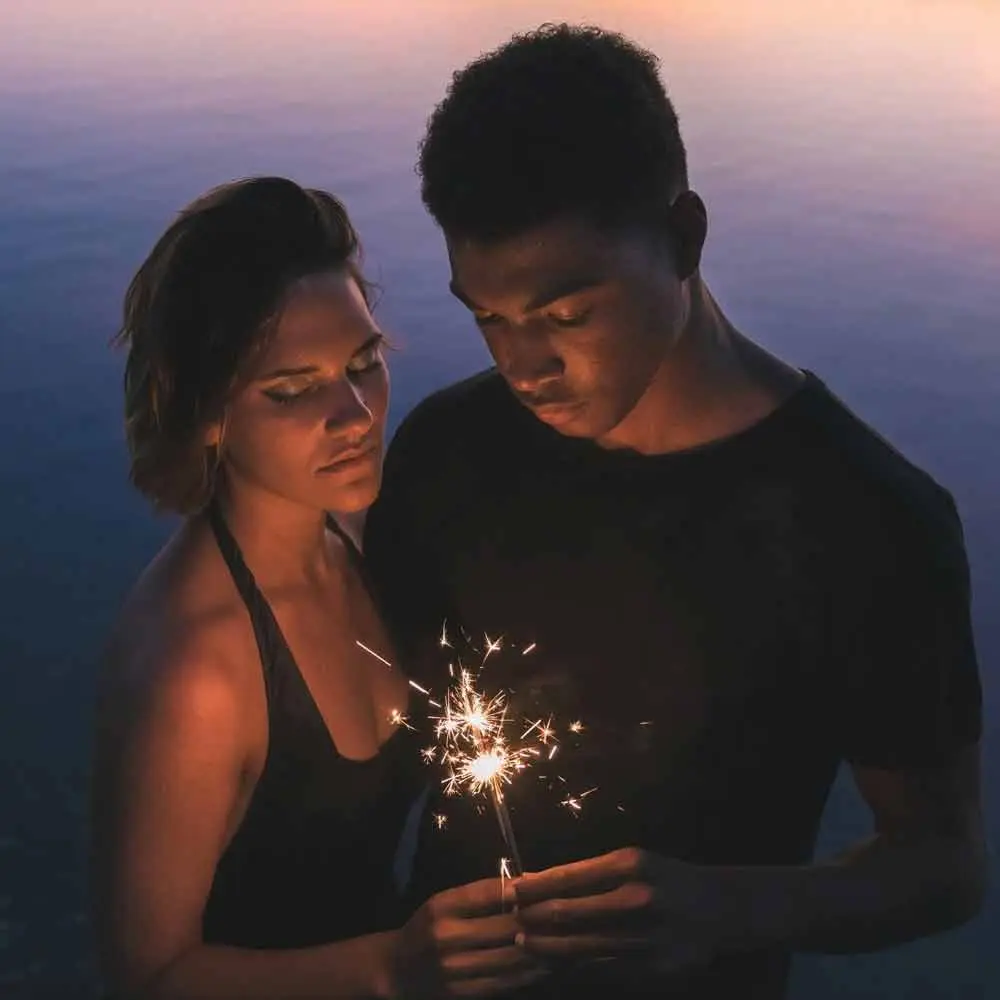 a man and woman holding sparklers