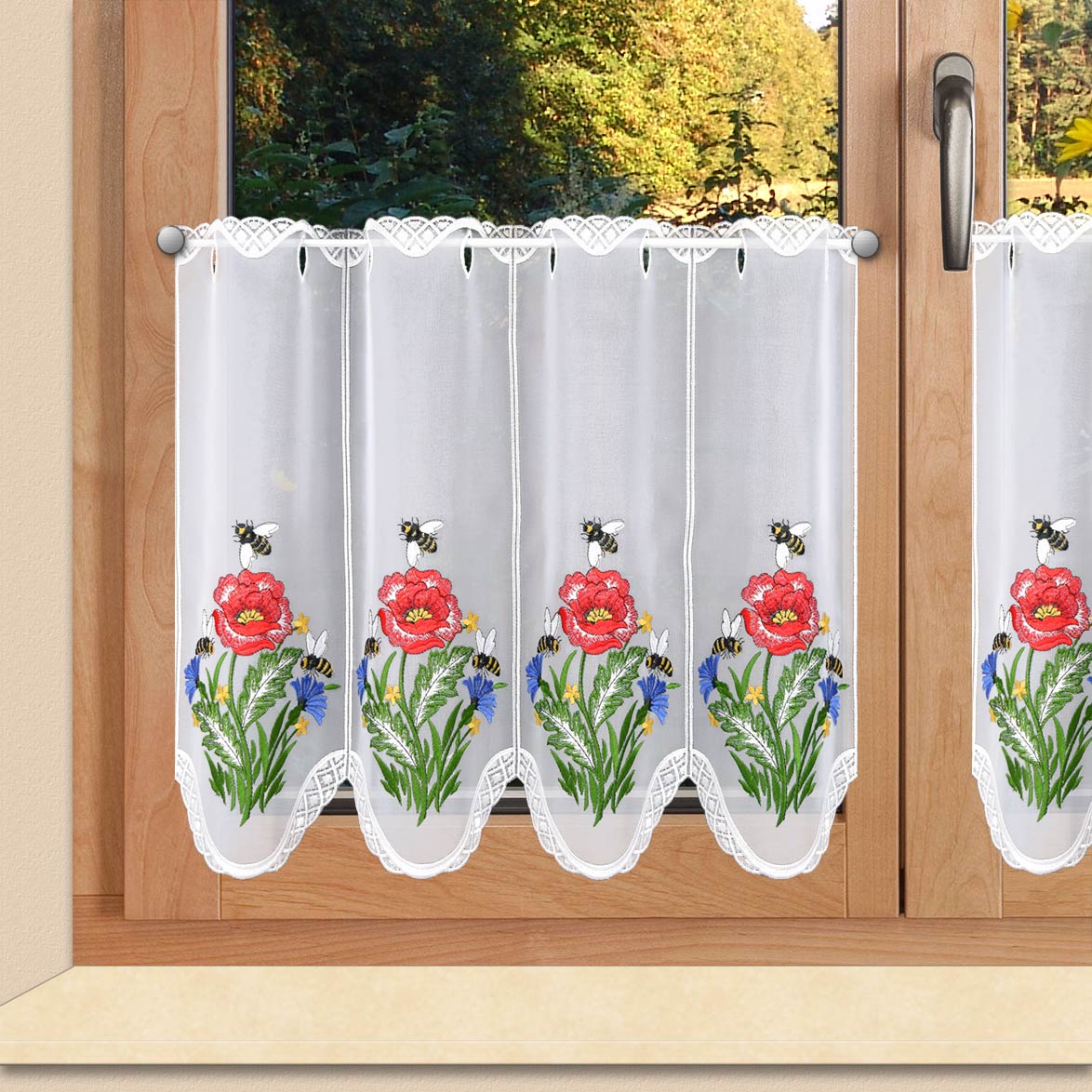 a window with white curtains and flowers