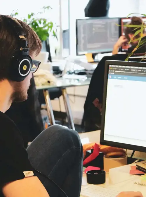 a man wearing headphones and sitting in front of a computer