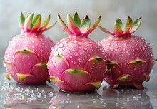 a group of pink fruit with green leaves