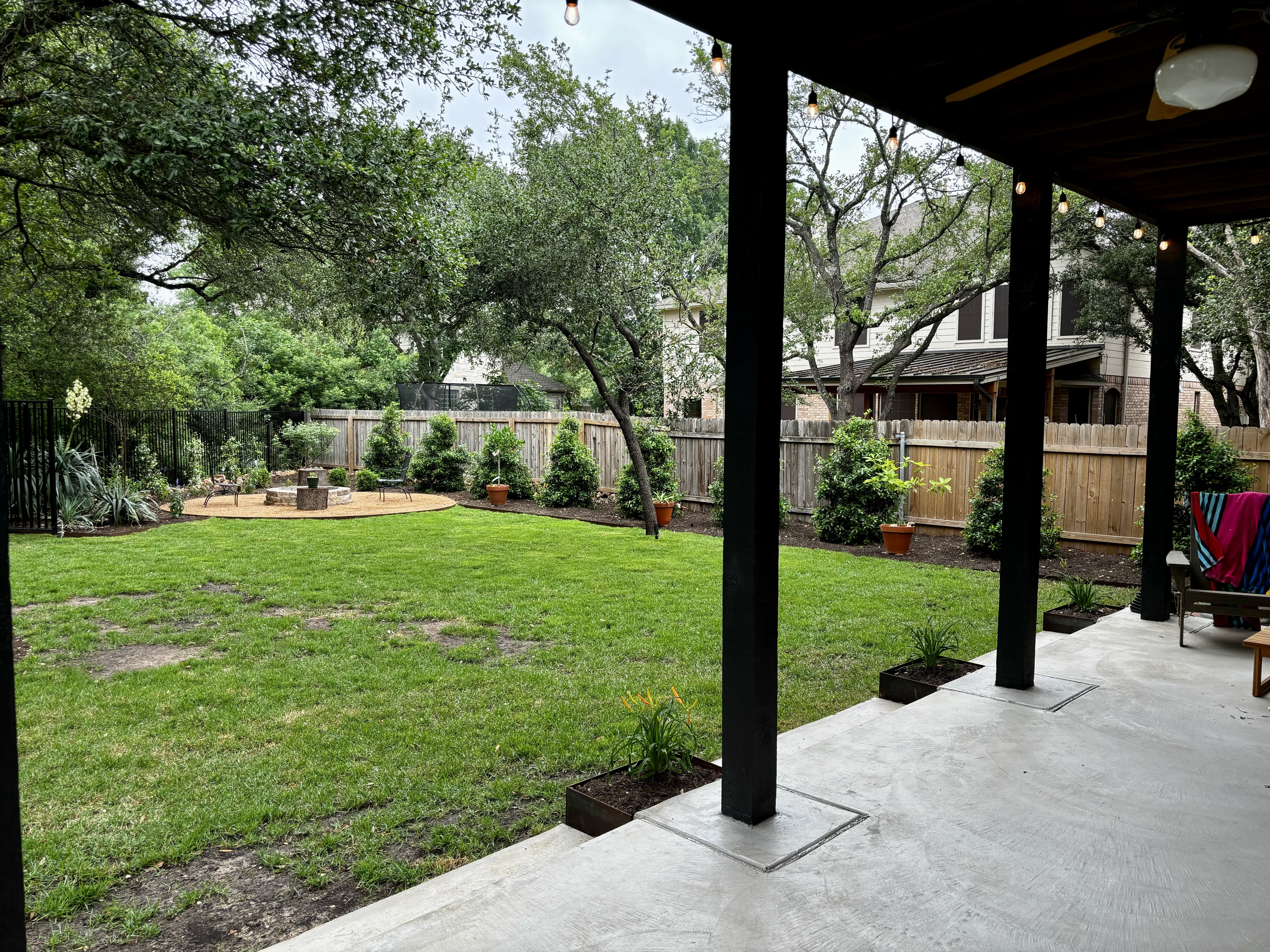 a patio with a lawn and trees