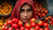 a woman with a red head scarf behind a pile of tomatoes