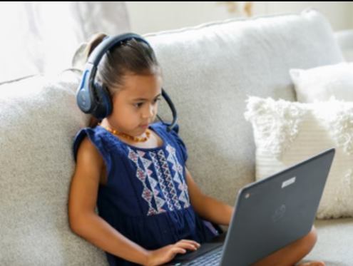 a girl wearing headphones and using a laptop