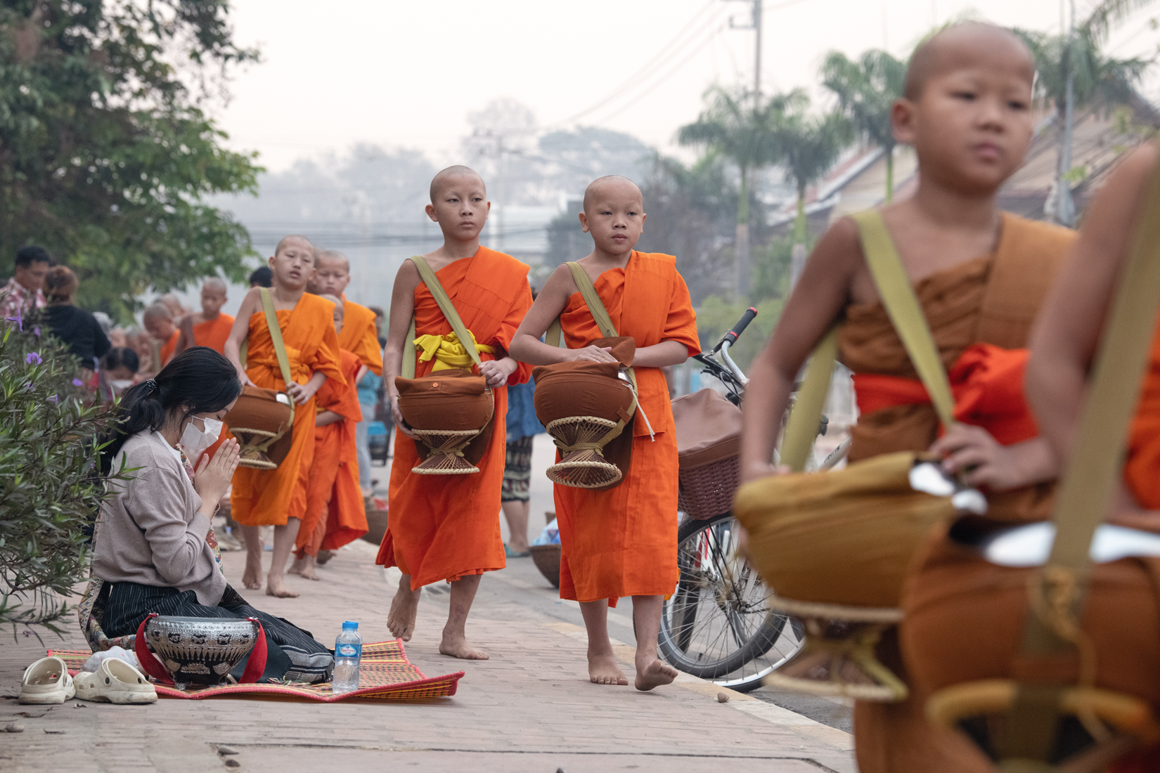 a group of young monks walking down a sidewalk