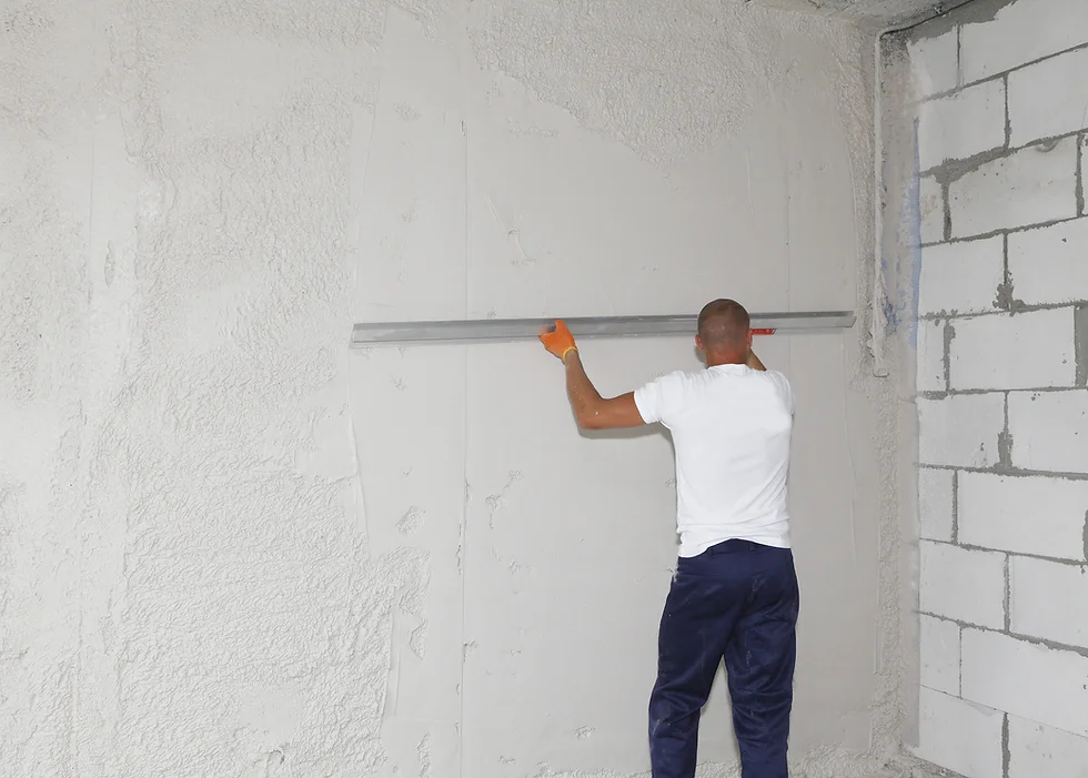 a man holding a metal rod over a wall