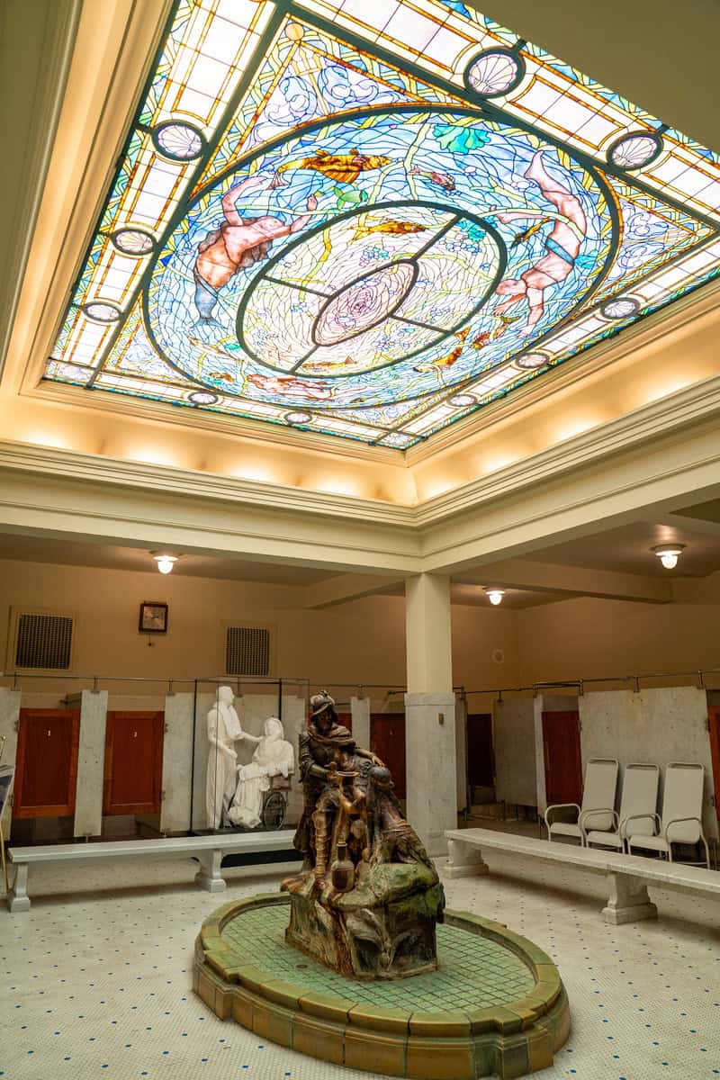 a stained glass ceiling in a room with a statue