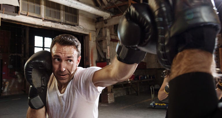 a man punching a bag with his arm out