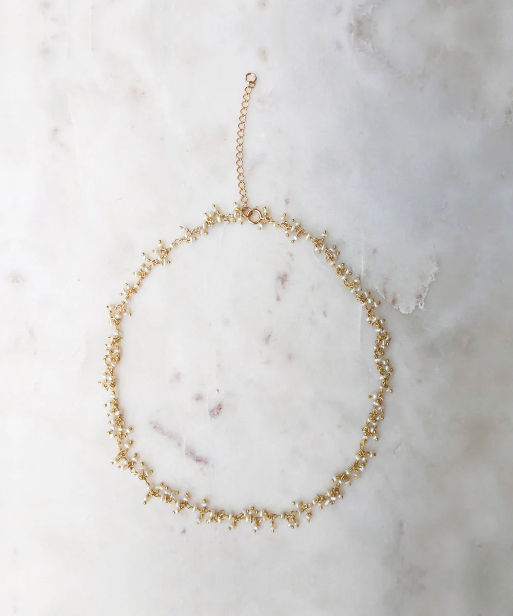 a gold necklace on a marble surface