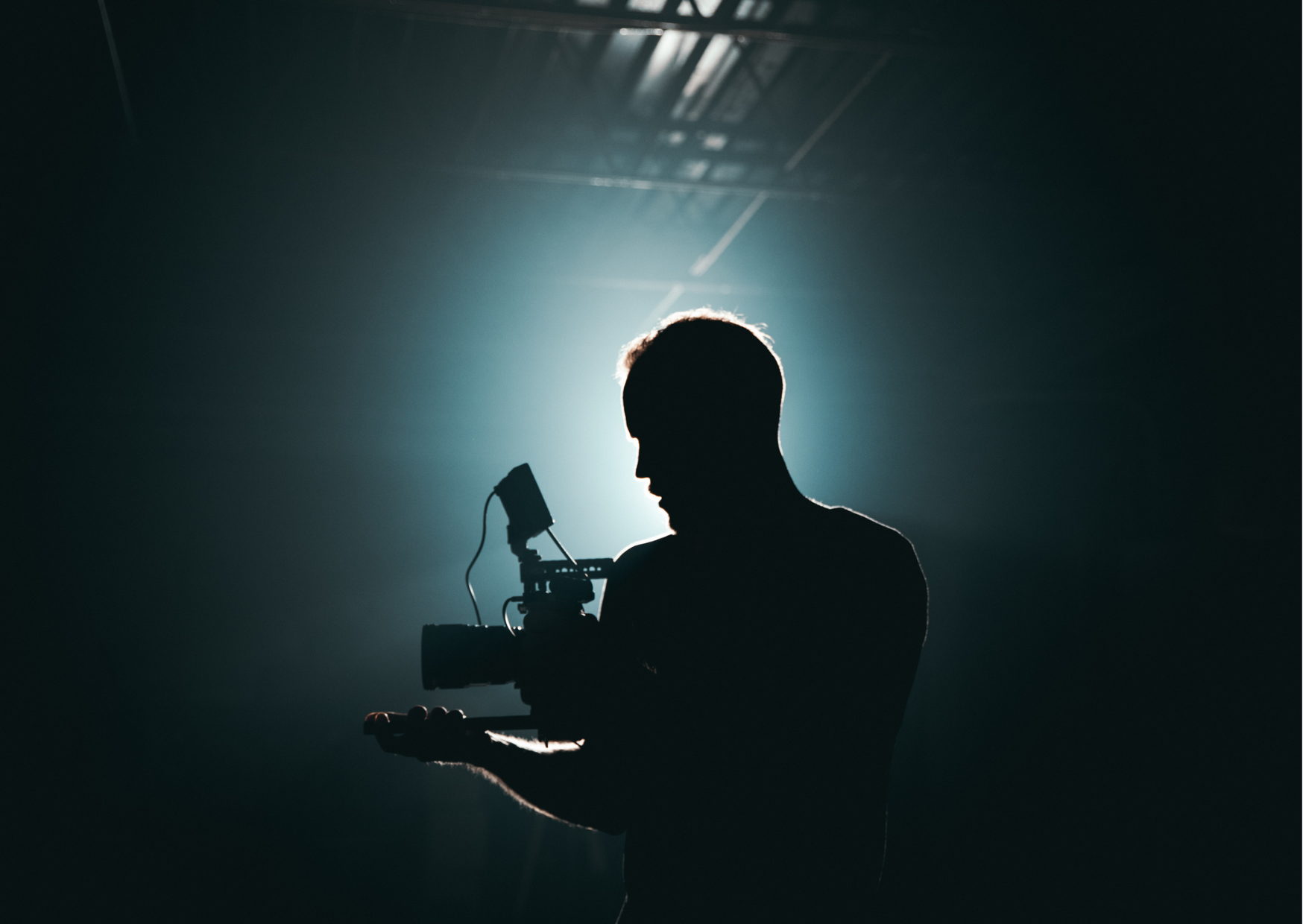 a silhouette of a man holding a camera