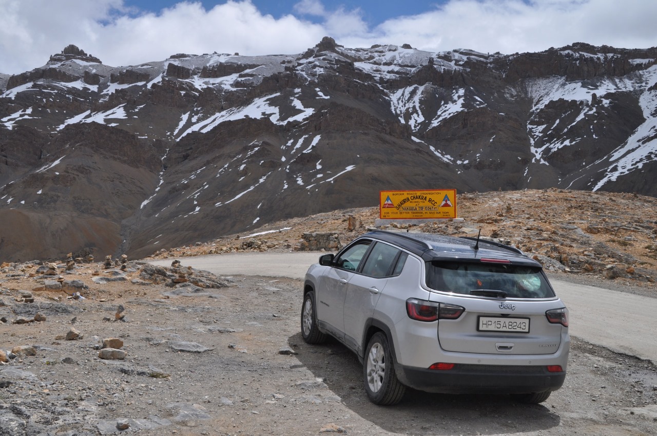 a car parked on a road with mountains in the background