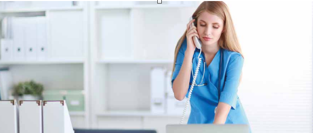 a woman in blue scrubs talking on the phone