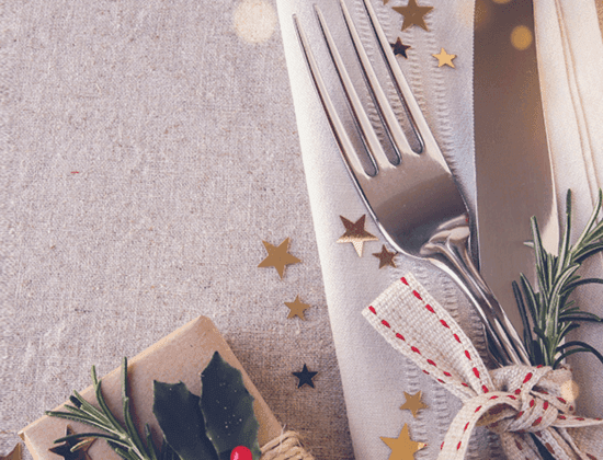 a fork and knife on a napkin with a wrapped present