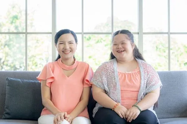 two women sitting on a couch smiling