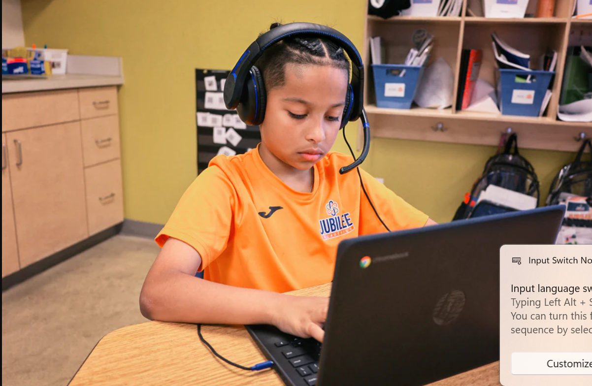 a boy wearing headphones and using a laptop