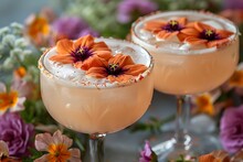 two glasses with orange liquid and flowers