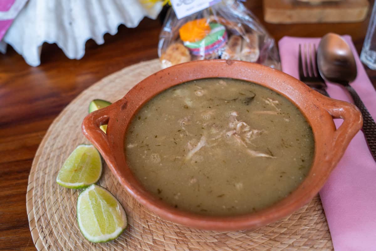 a bowl of soup with limes and a fork