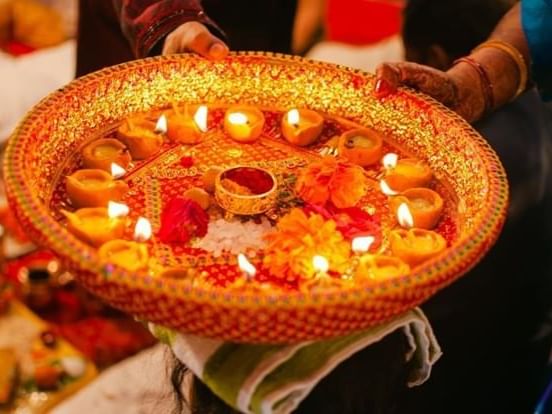 a person holding a plate with candles and flowers