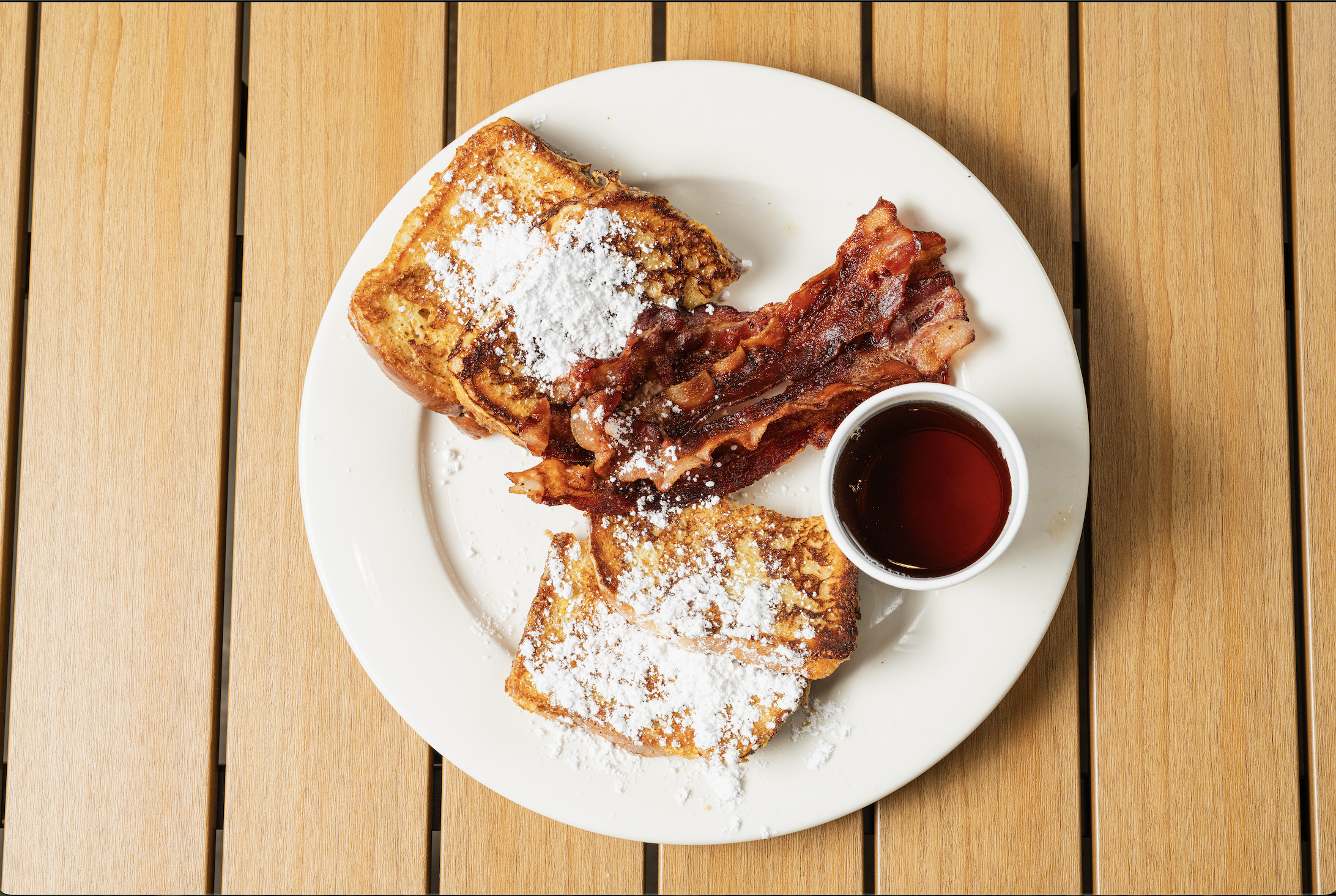 a plate of food with syrup and a cup of liquid